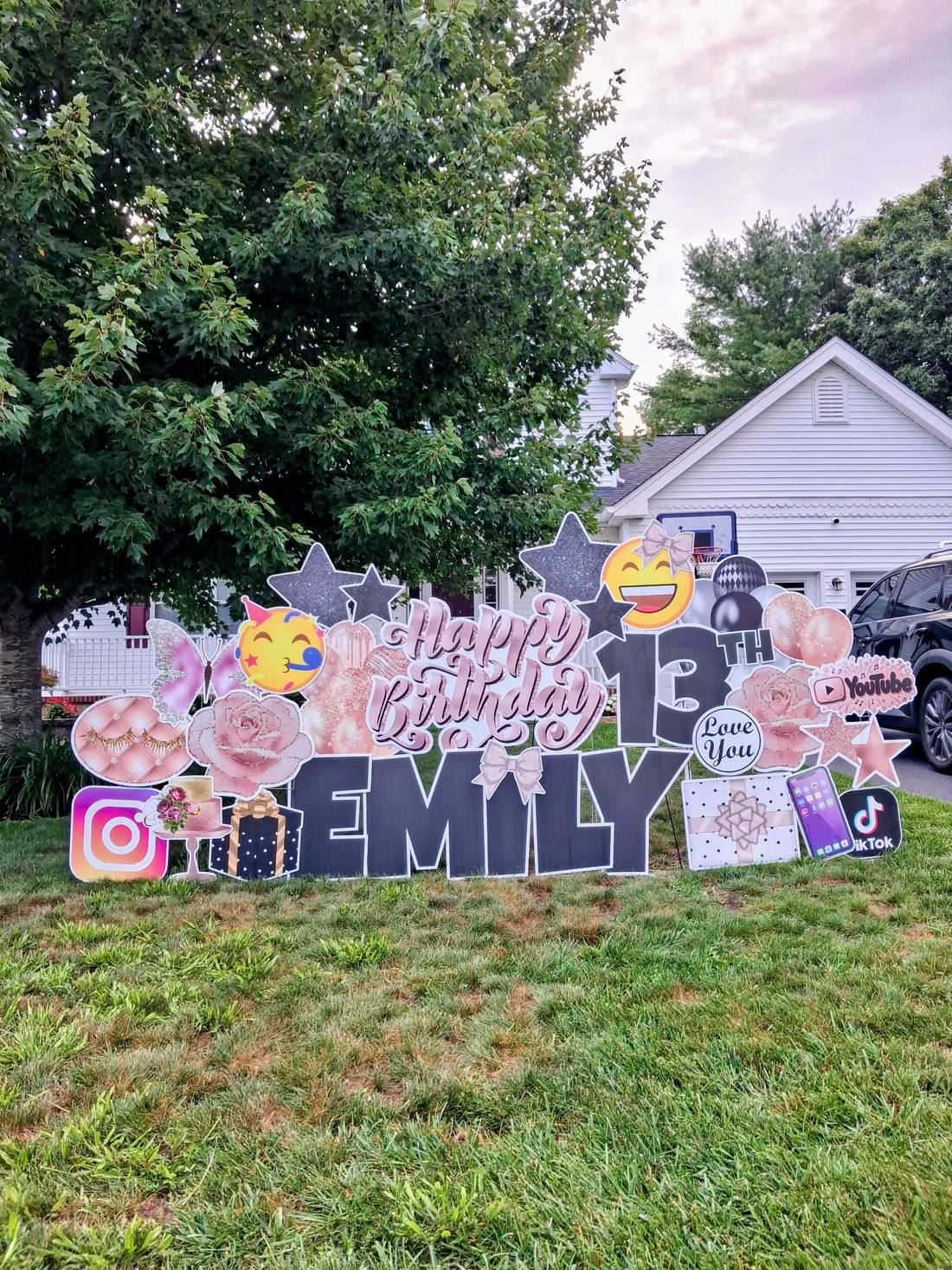 Happy 13th Birthday Emily rose gold yard card display with stars, balloons, and social media icons