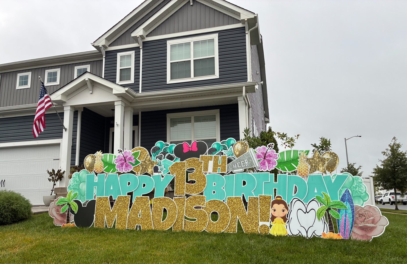 Happy 13th Birthday Madison tropical yard card display with gold glitter lettering, hibiscus flowers, palm trees, a surfboard and a cheer megaphone