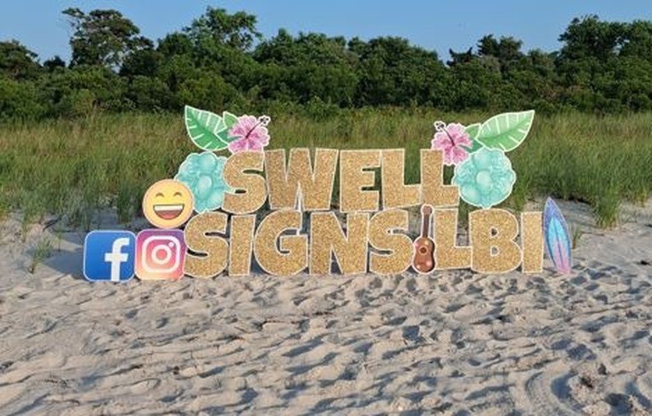 Swell Signs and Celebrations branded yard card display on the beach at Long Beach Island NJ